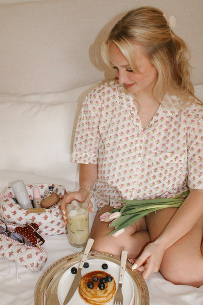 Woman relaxing in handmade floral block print cotton pajamas holding tulips and iced coffee, comfortable artisan sleepwear and loungewear set.